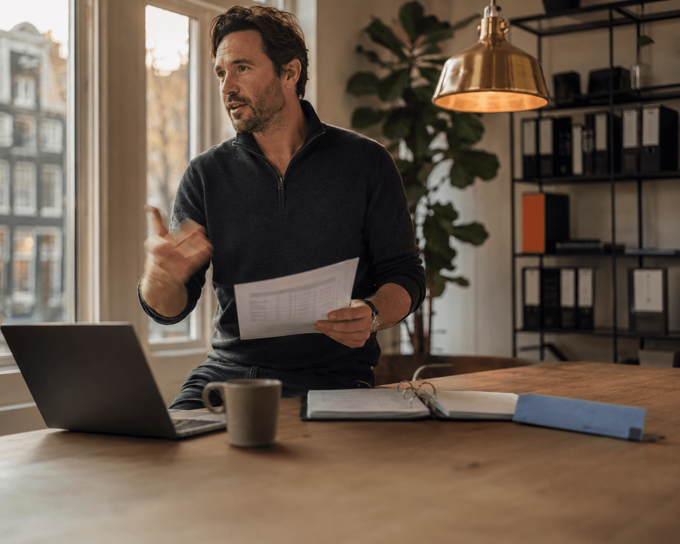 Oprichter aan een werktafel in een licht, modern kantoor