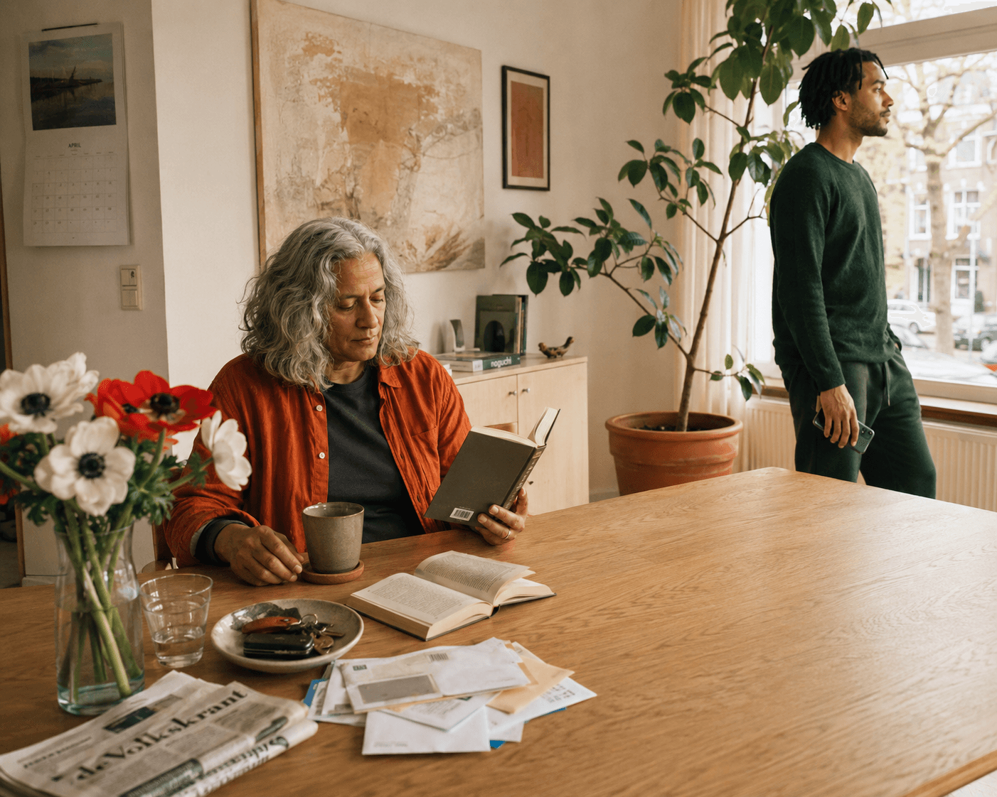 Twee generaties zitten samen aan een tafel in een lichte keuken